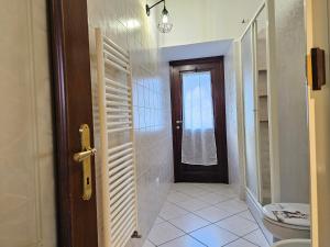 uma casa de banho com WC e uma porta com janela em Zoe Recidencias 2 em Boves