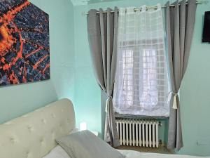 een slaapkamer met een bed en een raam met gordijnen bij Zoe Recidencias 2 in Boves