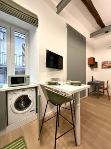 eine Waschküche mit einer Waschmaschine und einer Mikrowelle in der Unterkunft Sansepolcro33 in Neapel