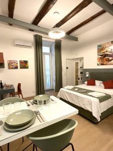 1 Schlafzimmer mit 2 Betten, einem Tisch und Stühlen in der Unterkunft Sansepolcro33 in Neapel