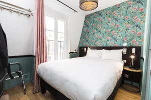 1 dormitorio con 1 cama grande y cabecero de flores en Vintage Paris Gare du Nord by Hiphophostels en París