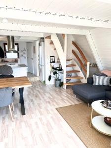sala de estar con sofá y escalera en Hyggeligt golfhus i Himmerland en Farsø