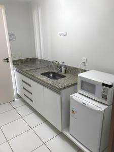 a kitchen with a sink and a microwave at LAGOA QUENTE FLATS in Caldas Novas