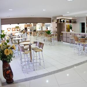 a restaurant with stools and tables and a cafeteria at LAGOA QUENTE FLATS in Caldas Novas