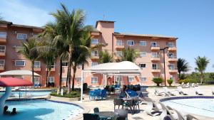 a resort with a pool and chairs and a building at LAGOA QUENTE FLATS in Caldas Novas