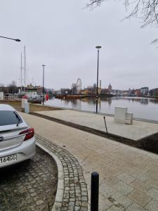 a white car parked next to a body of water at NADMOTŁAWIE in Gdańsk