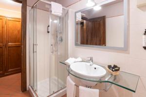 La salle de bains est pourvue d'un lavabo et d'une douche. dans l'établissement Antico Casale Di Scansano Resort, à Scansano