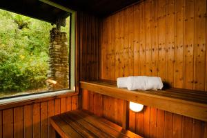 Habitación de madera con ventana y toalla en Haka House Franz Josef en Franz Josef