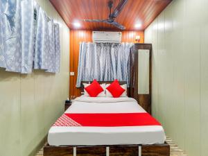 um quarto com uma cama grande e almofadas vermelhas em Super OYO Flagship Hotel Garden Inn em Mumbai