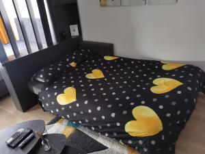 a bed with yellow hearts on it in a room at Apartman Vux in Banja Luka