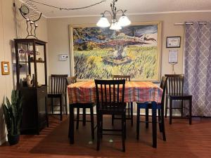 uma sala de jantar com uma mesa com cadeiras e um quadro em Hole in the Wall Getaway USA/Mexico em Columbus