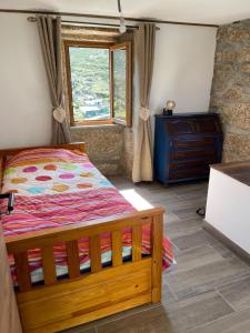 een slaapkamer met een bed, een raam en een dressoir bij Casa Pinhão in Sabugueiro