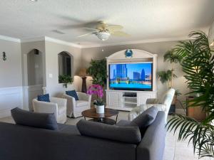 a living room with a couch and a tv at Dolphin Cove in Cocoa Beach Fl in Cocoa Beach