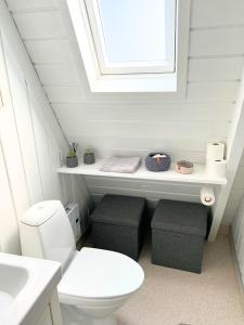 baño con aseo blanco y ventana en Hyggeligt golfhus i Himmerland en Farsø