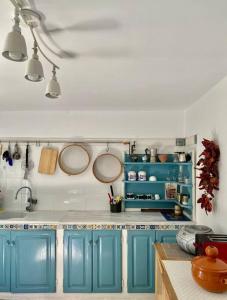 una cucina con armadi blu, pentole e padelle di Chez Chichi a Sicca Veneria