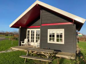 a small shack with a picnic table in front of it at Chalet in Friesland near Alde Feanen in De Veenhoop