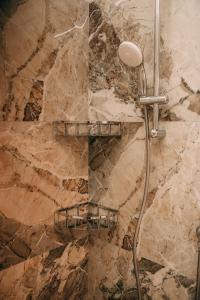 a shower in a bathroom with a stone wall at Verona Dolce Casa in Verona