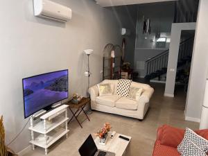 - un salon avec un canapé blanc et une télévision dans l'établissement LOFT SALAMANCA n 1, à Salamanque