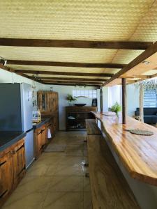 een grote keuken met een lang houten aanrecht bij Bungalow Miri in Tevaitoa