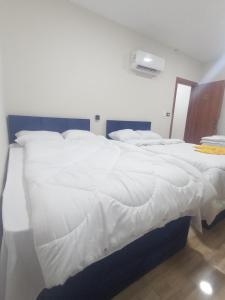 duże łóżko z białą pościelą i poduszkami w obiekcie Trafiko w Kairze