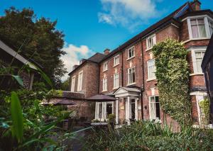 an old brick house with bushes in front of it at Best Western Valley Hotel in Ironbridge