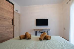 a bedroom with a bed with a tv on the wall at ELEGANCE SUITES in Plataria