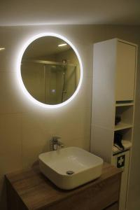 uma casa de banho com um lavatório e um espelho redondo em Casa Manuel e Maria em Fátima