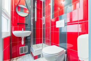 bagno rosso con servizi igienici e lavandino di Young and Happy Latin Quarter by Hiphophostels a Parigi