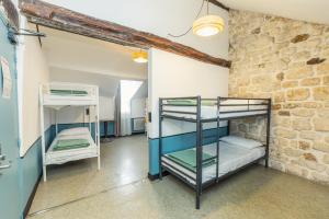 a room with bunk beds and a brick wall at Young and Happy Latin Quarter by Hiphophostels in Paris