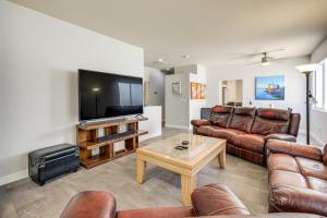 a living room with leather furniture and a flat screen tv at Desert Escape with Pool Oasis Near Golfing and Vegas! in Las Vegas