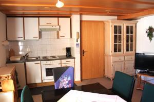 una cucina con armadi bianchi, tavolo e sedie di Appartement Isolde a Dornbirn