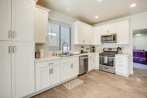 a white kitchen with white cabinets and appliances at Desert Escape with Pool Oasis Near Golfing and Vegas! in Las Vegas