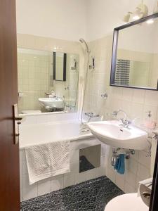 La salle de bains est pourvue d'une baignoire, d'un lavabo et d'un miroir. dans l'établissement Bright Studio with View, à Innsbruck