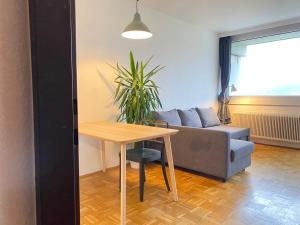 uma sala de estar com uma mesa e um sofá em Bright Studio with View em Innsbruck