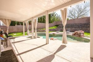 a patio with a pool and a table and chairs at Desert Escape with Pool Oasis Near Golfing and Vegas! in Las Vegas