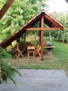 a wooden pavilion with a table and chairs in the grass at Cabañas Buen Recuerdo in Puyehue