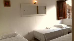 sypialnia z 2 łóżkami i lustrem na ścianie w obiekcie Pousada Catarina Mina w mieście São Luís