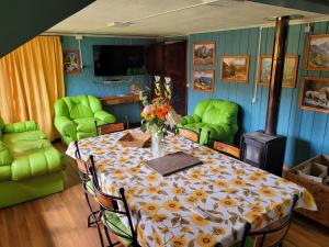a dining room with a table with flowers on it at Cabañas Buen Recuerdo in Puyehue