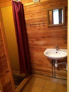 a bathroom with a sink and a red shower curtain at Līgatnes Zemturi in Augšlīgatne