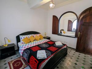 een slaapkamer met een bed en een spiegel aan de muur bij Surfstay Taghazout 2 in Taghazout