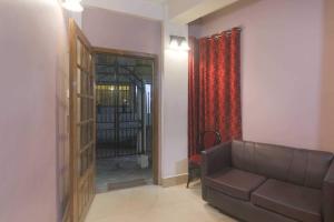 uma sala de estar com um sofá e uma porta de vidro em Am Bed And Breakfast em Shillong