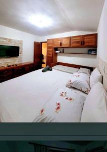 una camera da letto con un grande letto bianco con fiori sopra di Top Houses tem Paraíso Tropical Village no Centro a Arraial d'Ajuda Altre 43 foto