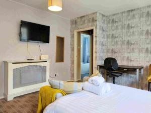 a bedroom with a bed with a tv and a fireplace at amazing apartments - Websters Land - Castle View in Edinburgh
