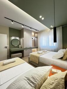een hotelkamer met twee bedden en een spiegel bij Luxurious seaside apartment 1 in Durrës