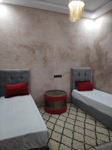 een kamer met 2 bedden en een salontafel bij Villa darna ourika in Ourika