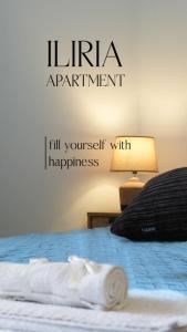 a sign that reads lirida apartment with a bed at ILIRIA Apartment in Durrës