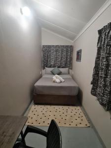 a small bedroom with a bed and a chair at Southernwood nest in East London