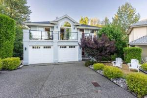 a house with a white garage and two white chairs at 2 Bedroom Private Guest Suite on a hill in Abbotsford