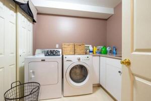 eine Waschküche mit einer Waschmaschine und einer Theke in der Unterkunft 2 Bedroom Private Guest Suite on a hill in Abbotsford
