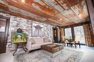 a living room with a couch and a brick wall at Fairytale: Hot Tub & Trout Stream & Petting Zoo? in Sugar Grove